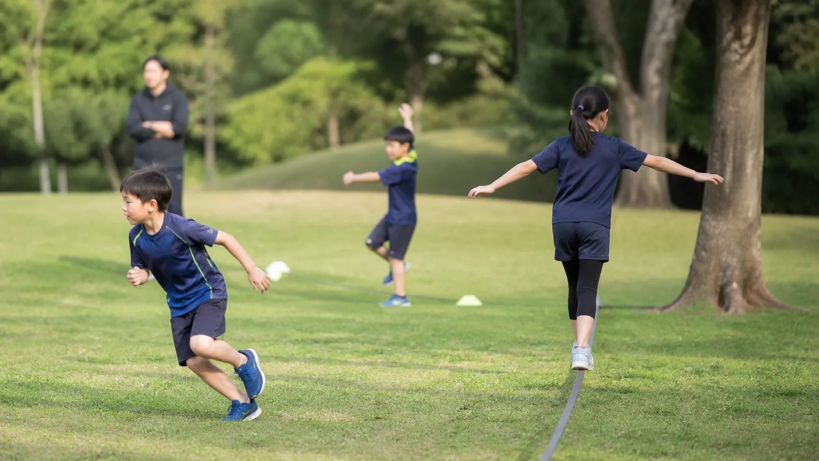 公園で異なる方向へ動きながら運動する日本人の子どもたち