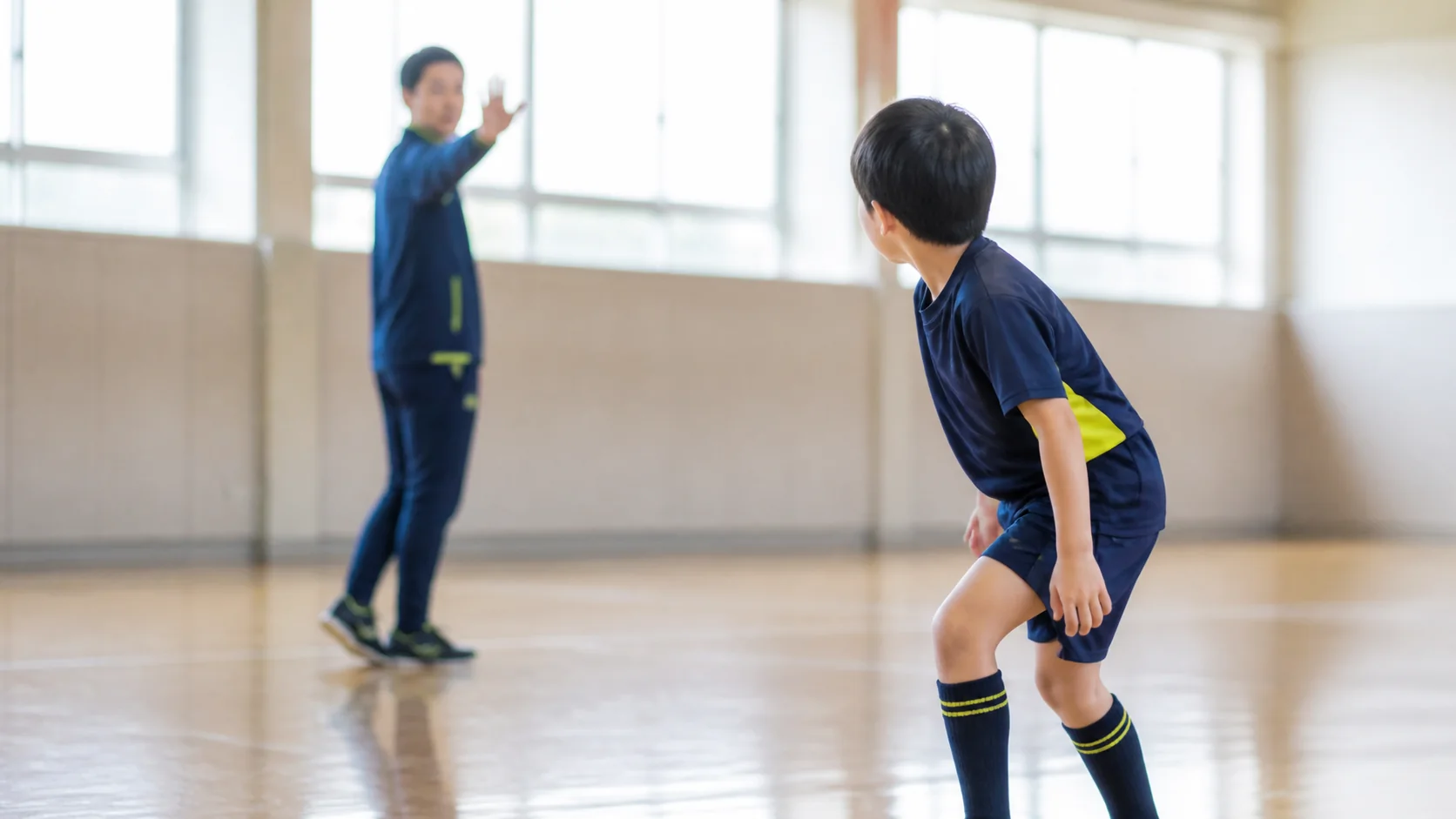 体育館で合図を見て動き出そうとする日本人の子ども