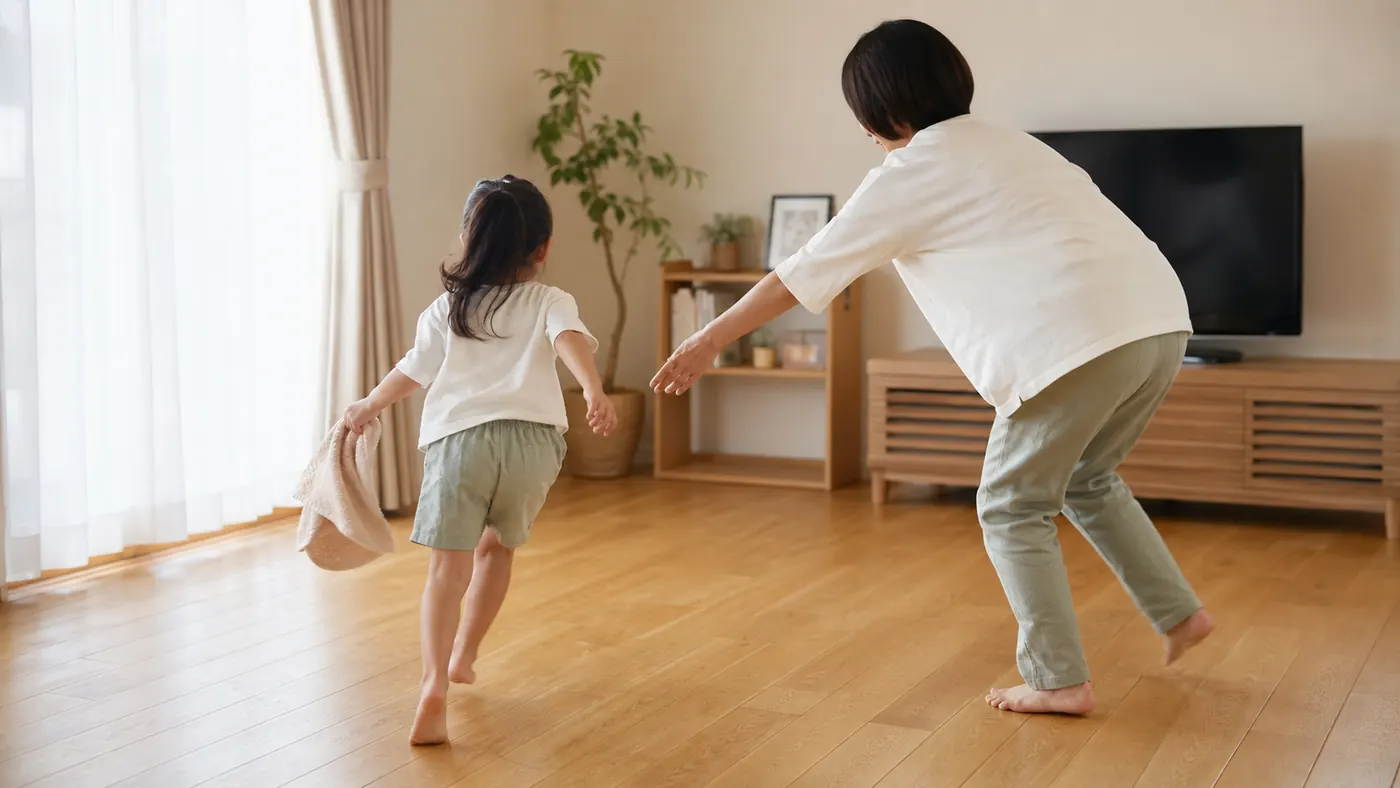 自宅のリビングでタオルを使って遊ぶ日本人の親子