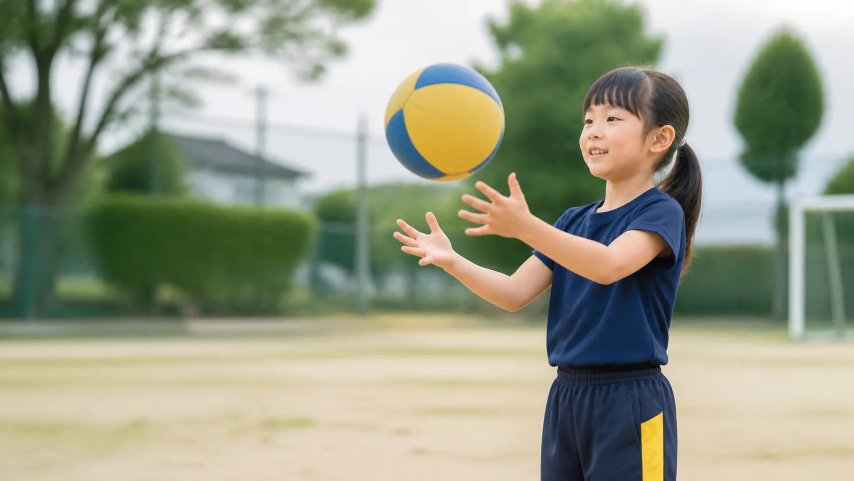 屋外で柔らかいボールを受けようとする日本人の子ども